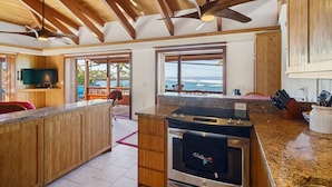 Una cocina con una isla grande, armarios de madera y vistas al exterior.