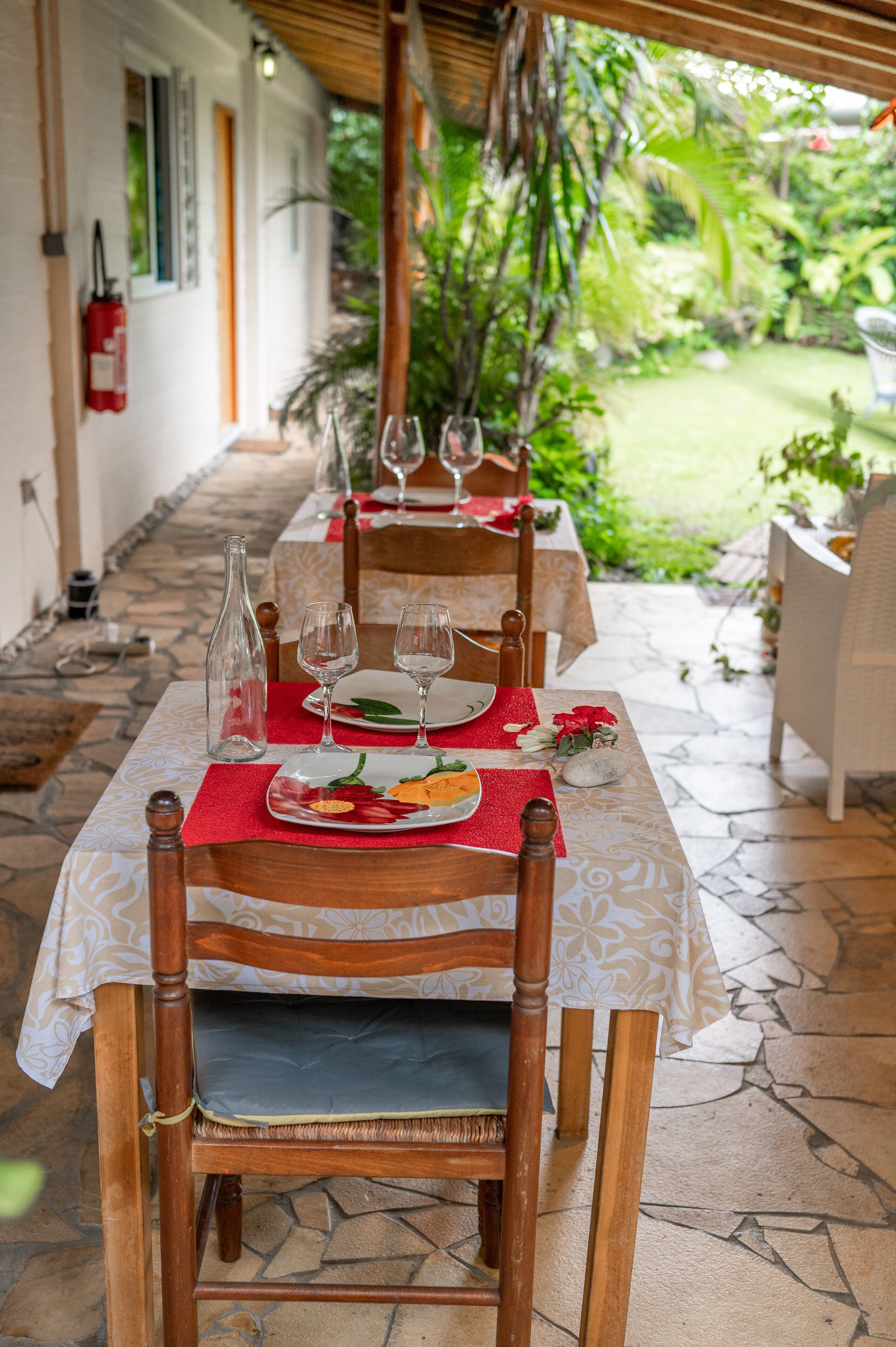 Comedor con mesas dispuestas para dos, con manteles blancos y sillas de madera.