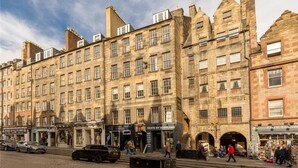 A historic building with multiple shops on the ground floor, including 'Taste of Scotland' and 'House of Scotland'. - Stunning 5BR Royal Mile Penthouse (Edinburgh)