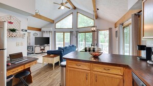 A spacious kitchen with wooden cabinets, a large island, and a dining area with a blue sofa.