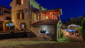 A two-story stone house with a balcony and a small garden area. - Amazing home in Polje (Polje)