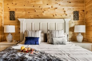 Relax in this inviting bedroom with a classic design, featuring a central bed, nightstands, and a cozy throw blanket.