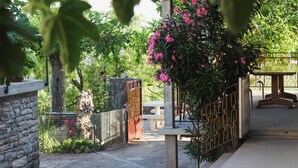 A stone wall, a metal gate, and a bench in a garden setting.