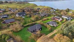 Ett bostadsområde vid kusten med hus, varav några har garage som är sammanbyggda med huset, och med fri utsikt över havet.