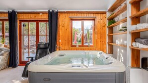 Et spa-rum med jacuzzi, trævægge og udsigt til det fri.