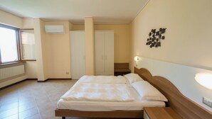 Une chambre à coucher avec un lit, des tables de chevet, une armoire et un radiateur.