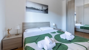 A hotel room with a bed, a nightstand, a lamp, a painting, and a mirror. - Cozy and bright 45 sqm apartment, perfect for 2 people, located on the first floor of a building with a lift (not suitable for disabled people). The accommodation is located in a neighborhood served by all the main services: bars, restaurants, supermarke (Pisa)