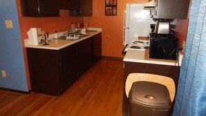 A compact kitchen with dark cabinets, a white countertop, and a stove. - Perfect Fayetteville Stay-cation in Cozy 2-Bed, 2-Bath Townhome (Fayetteville)
