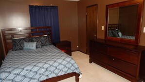 A bedroom with a bed, dresser, and a mirror. - Perfect Fayetteville Stay-cation in Cozy 2-Bed, 2-Bath Townhome (Fayetteville)