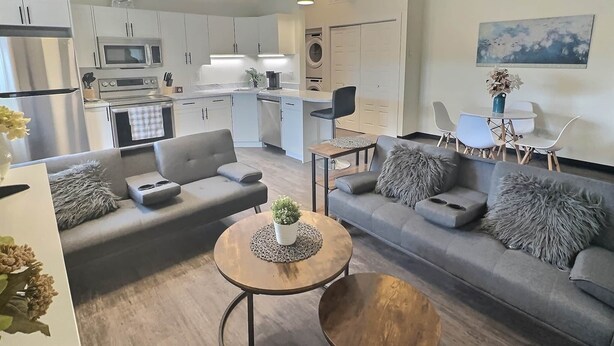 A modern apartment with a living room, kitchen, dining area, and a small balcony. - Brooklynn Suite - Pet Friendly - Dukes Place (Brandon)