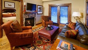 A cozy living room with a fireplace, a television, and a comfortable seating area. - Innsbruck Aspen | Deluxe One-Bedroom Junior Suite 03 w/ Hot tub, Centrally located (Aspen)