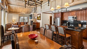 A spacious dining area with a wooden table, leather chairs, and a chandelier. - The Ritz-Carlton Club 3BD Penthouse 4301, Ski-in & Ski-out (Aspen)