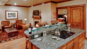 A spacious living area with a fireplace, a dining area with a granite countertop, and a cozy seating arrangement.