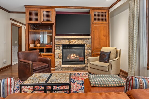 A cozy living room with a fireplace, leather armchairs, and a coffee table. - The Ritz-Carlton Club | Two-Bedroom WR 2305, Ski-in & Ski-out Resort in Aspen Highlands (Aspen)
