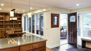 A modern kitchen with a large island, wooden cabinetry, and pendant lighting.