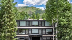 A modern two-story building with a flat roof, large windows, and a number '926' displayed at the entrance. - Chateau Snow Unit 202 | Renovated Condo with Great Natural Light, Excellent Location (Aspen)