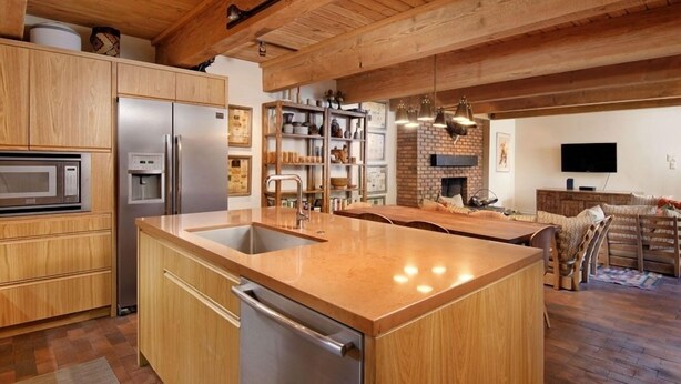 A modern kitchen with wooden cabinets, stainless steel appliances, and a central island. - Cottonwoods Unit 1C | Downtown Condo with Upgraded Kitchen & Bathrooms (Aspen)