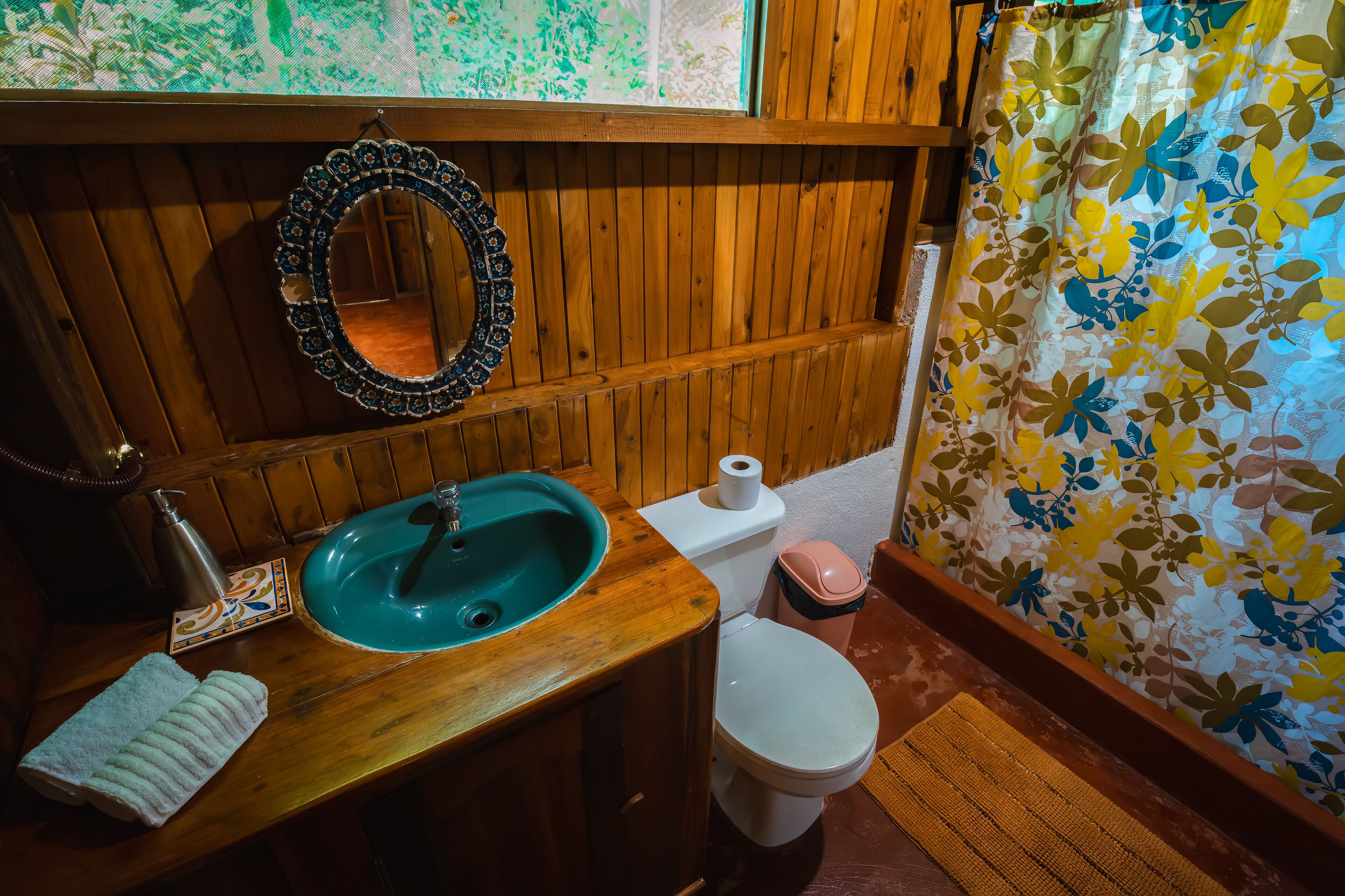 Une salle de bain en bois avec un lavabo, des toilettes et un miroir.