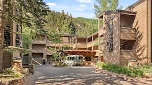 Un hotel de varios pisos con un patio central, asientos al aire libre y una zona cubierta.