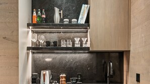 A compact kitchen with a black marble backsplash, wooden cabinets, and a built-in dishwasher. - Independence Square 301 | Great Hotel Room with Excellent Location & Rooftop Hot Tub (Aspen)