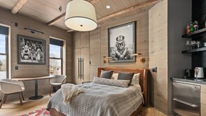 A modern bedroom with a large bed, a desk, and a kitchenette. - Independence Square 301 | Great Hotel Room with Excellent Location & Rooftop Hot Tub (Aspen)
