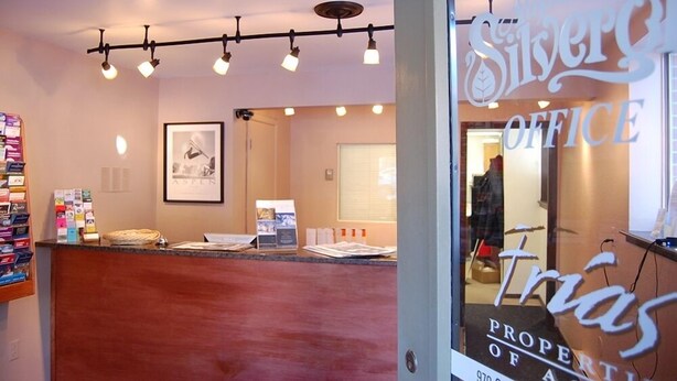 A reception area with a counter, framed artwork, and a sign for 'Silvers Office'.