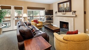 Una sala de estar con chimenea, un sofá, una mesa de centro y un televisor.