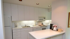 A modern kitchen with white cabinets, a microwave, a coffee maker, and a telephone on the counter. - Riverview Unit 8 | All the Essentials Riverside Condo with Access to Pool & Hot Tub (Aspen)