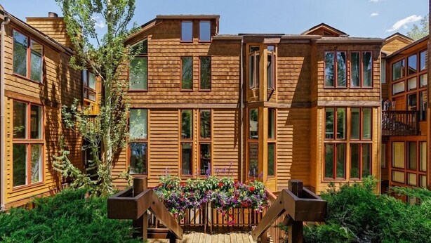 A wooden cabin with a central wooden deck and flower boxes. - Old Hundred Unit 102 | Townhouse with Treetop Views & Excellent Location, 3 Blocks to Ski Slopes (Aspen)
