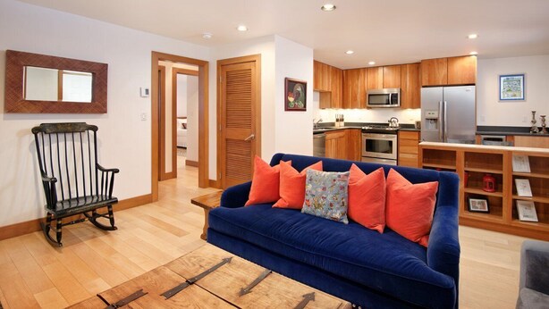 A modern kitchen with wooden cabinets, a microwave, and a refrigerator.