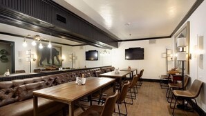 A restaurant with a long wooden table, leather booth seating, and a modern interior design. - Independence Square Unit 309 | Downtown Hotel Room with A/C in Aspen, Wet Bar & More (Aspen)