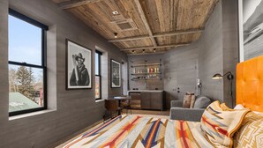 Une chambre moderne avec un grand lit, un bureau et un coin cuisine.