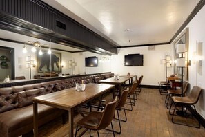 Enjoy meals in this stylish dining area with a long table, comfortable seating, and flat-screen TVs.