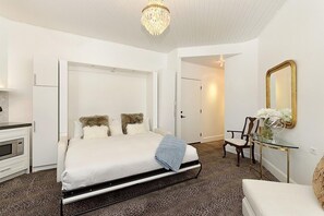 Relax in a stylish room with a comfortable bed, a glass coffee table, and a large mirror.