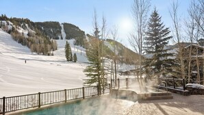 A hot spring area with a pool, surrounded by snow-covered terrain and trees. - The Ritz-Carlton Club | Two-Bedroom WR Residence 2412, Ski-in & Ski-out Resort in Aspen Highlands (Aspen)
