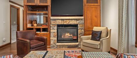 Una sala de estar acogedora con chimenea, sillones de cuero y una mesa de centro.