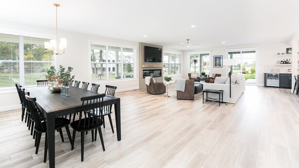 A spacious living area with a dining table, sofas, and a TV.