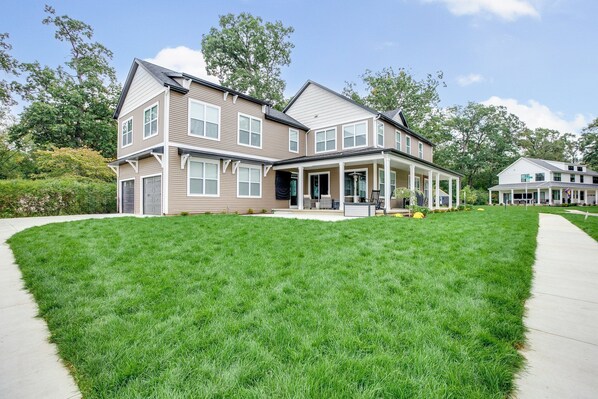 A two-story house with a front porch and a well-maintained lawn.