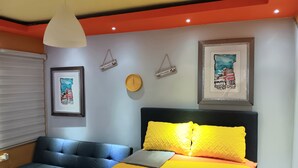 Ein Schlafzimmer mit einem Bett, einer Couch, einer Wanduhr und zwei Willkommensschildern.