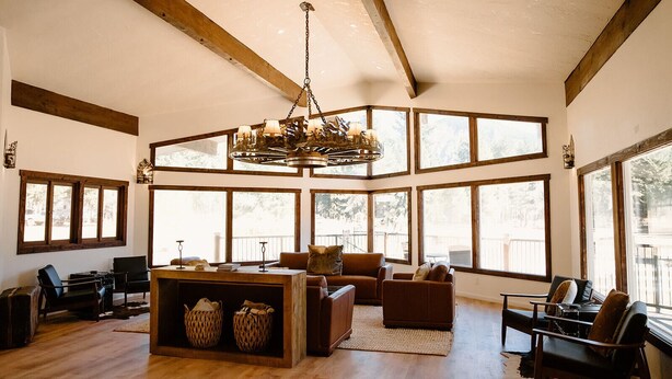 A spacious living room with large windows, a wooden ceiling, and a chandelier. - Silver Ridge Ranch (Easton)