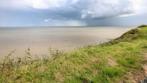 A beach with a grassy foreground and a cloudy sky. - 63 The Waterside Holiday Park (Lowestoft)