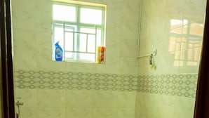 Une salle de bain avec une baignoire, des toilettes et une fenêtre.