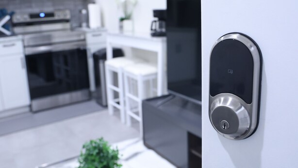 A modern kitchen with stainless steel appliances, a dining area with white furniture, and a door with a digital lock. - My Cozy-Snug Place - 1Brd - 8 mins to EWR (Elizabethport, NJ)