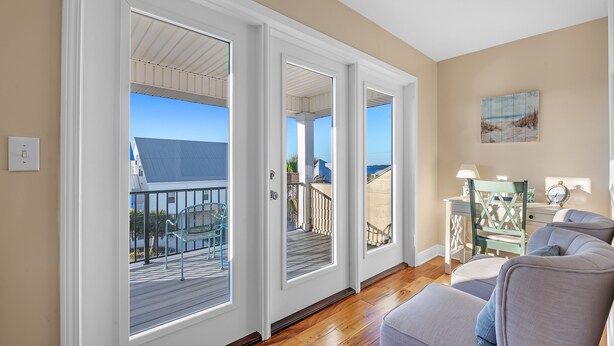 A room with a balcony, a desk, and a chair.