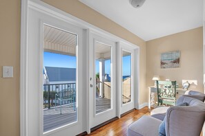 Een kamer met balkon, bureau en stoel.