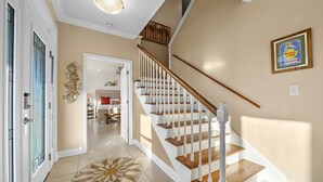 A staircase with wooden steps and white railings leading to an upper floor.