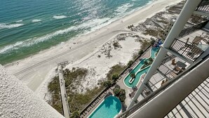 Um hotel alto com piscina e acesso à praia.