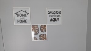 Two black chairs, a potted plant, and three wall decorations in a room. - Luxo e conforto  (Goiania)