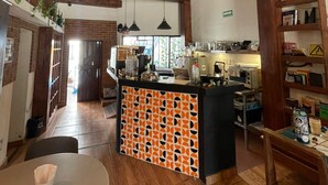 Una cocina con una isla central, vigas de madera y un comedor con una mesa redonda.