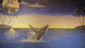A whale breaching the water with a moonlit sky and palm trees in the background.